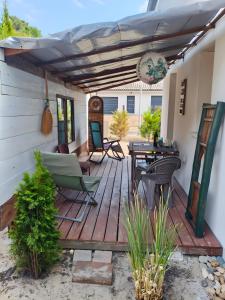 a wooden deck with chairs and a table at Villa proche plage pour 3 pers in Vielle-Saint-Girons +12 photos