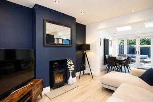a living room with blue walls and a fireplace at Super Modern 3 bedroom semi-detached. in Rugby