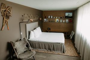 a bedroom with a bed and a chair at OVERLOOK Lodge by CERVO Zermatt in Zermatt +36 photos
