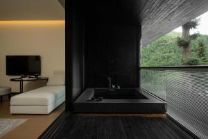 a room with a bath tub with a large window at Magnolia Maison in Garze
