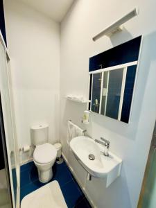 a white bathroom with a toilet and a sink at Casa Rosa Sousa in Felgueiras