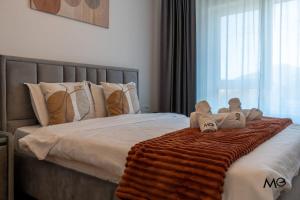 a bed with a blanket and two teddy bears on it at Noua Suites in Braşov
