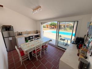 a kitchen and dining room with a table and a pool at Mas Cairou in Sorède