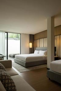 a bedroom with two beds and a large window at Magnolia Maison in Garze