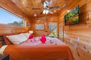 a bedroom with a bed and a ceiling fan at Rustic Mountain Retreat by Ghosal Luxury Lodging in Pigeon Forge +49 photos