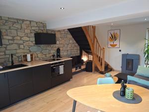 a kitchen and living room with a stone wall at La Cachette de Simone in Spa