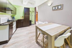 a kitchen and dining room with a wooden table and chairs at Le Cocoon Fuchsia in Romilly-sur-Seine
