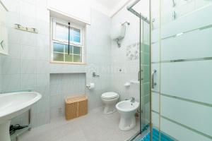 a bathroom with a shower and a toilet and a sink at Villa Cesare in Torre Specchia Ruggeri +34 photos