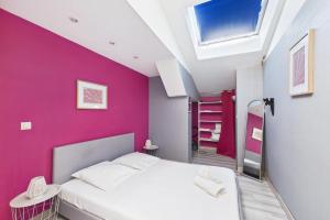 a bedroom with a white bed and a pink wall at Le Cocoon Fuchsia in Romilly-sur-Seine