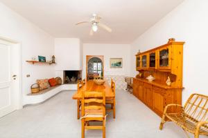 a dining room with a wooden table and chairs at Villa Cesare in Torre Specchia Ruggeri