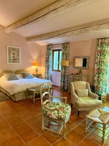 a bedroom with a bed and a chair at Mas de Fauchon - Teritoria in Saint-Cannat