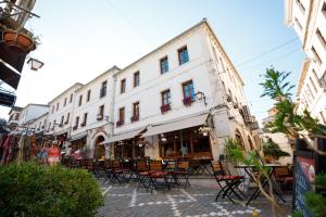 a street with tables and chairs in front of a building at Hotel Kashah in Gjirokastër