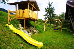 a playground with a slide and a wooden tower at Schmiedlehnerhof in Birnberg