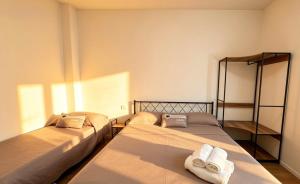 two beds in a room with towels on them at Casa Gigi a Sottomarina in Chioggia
