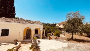 a small white house with a tree in front of it at Casa Bellina ,Potamos Private Garden & Free Parking in Evropoúloi