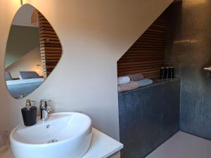 a bathroom with a sink and a mirror at La Cachette de Simone in Spa +10 photos