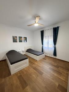 a bedroom with two beds and a ceiling fan at Villa Mia in Marchena +12 photos
