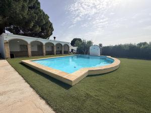 a large swimming pool in the middle of a yard at Villa Mia in Marchena