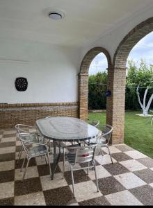 a patio with a table and chairs on a checkered floor at Villa Mia in Marchena