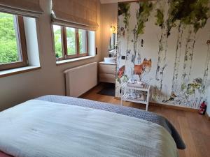 a bedroom with a bed in a room with a bathroom at La Cachette de Simone in Spa