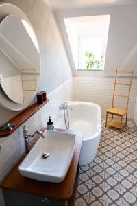 a bathroom with a sink and a tub and a mirror at Villa Weißbach - Haus Hilda in Flöha +56 photos