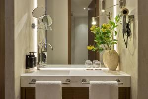 a bathroom with a white sink and a mirror at Glinter Barrio de las Letras - Apartments in Madrid +32 photos