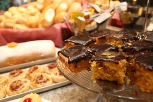 a table with a plate of cakes and pastries at Mengo Palace Hotel in Rio de Janeiro