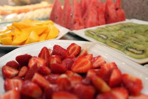 a table topped with plates of strawberries and other fruit at Mengo Palace Hotel in Rio de Janeiro