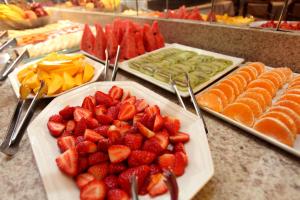 a table topped with plates of strawberries and fruit at Mengo Palace Hotel in Rio de Janeiro