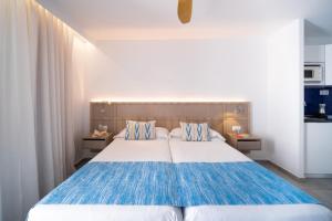 a bedroom with a blue and white bed with two pillows at Seaclub Alcudia in Port d'Alcudia +66 photos