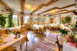 a restaurant with tables and chairs in a room at Hotel Häuserl im Wald in Mariapfarr