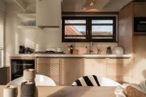 a kitchen with a table and a window in it at Dutchen Vakantiepark Duynvoet in Schoorl +178 photos