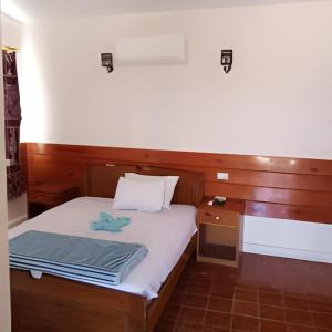 a small bedroom with a bed and a desk at elwaharesort in Wāsiţ
