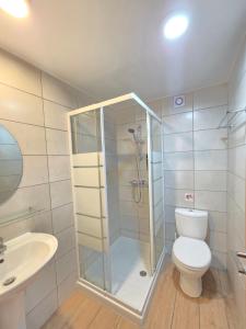 a bathroom with a shower and a toilet and a sink at Harrys Inn Guesthouse in Larnaca