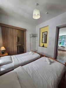 a room with three beds and a window at Harrys Inn Guesthouse in Larnaca