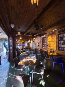 a dining room with tables and chairs and books at Harrys Inn Guesthouse in Larnaca