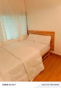 a bed with white sheets and pillows in a room at Atupim Royal in Janman