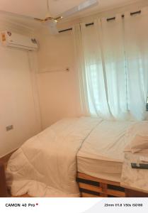 a small bedroom with a bed and a window at Atupim Royal in Janman