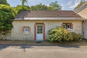a small brick house with a white door at Gîte Mélany in Chargé