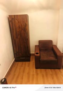 a brown couch in a room with a wooden cabinet at Atupim Royal in Janman