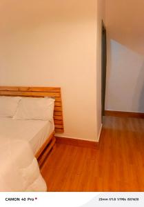 a bedroom with a bed and a wooden floor at Atupim Royal in Janman