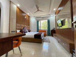 a bedroom with a bed and a desk and a tv at Jayati Palace Hotel in Rudraprayāg +7 photos