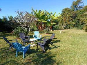 a group of chairs and a table in the grass at Le ptit coin mont vert in Saint-Pierre