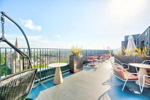 a balcony with tables and chairs on a building at Argyl - The Apiary, Ealing in Ealing +6 photos