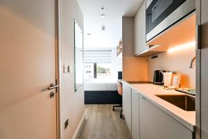 a kitchen with a sink and a bed in a room at Argyl - The Apiary, Ealing in Ealing