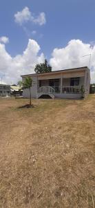 a house with a tree in front of it at Au D LOCATION in Grand-Bourg