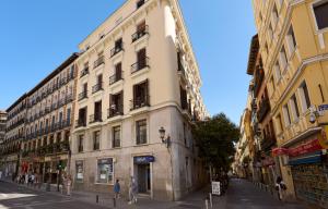 a tall building on a city street with people walking around it at Glinter Barrio de las Letras - Apartments in Madrid