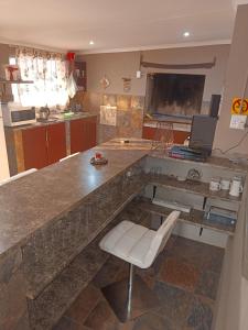 a kitchen with a large counter with a white chair at Skaap Kraal Guest Farm in Kakamas