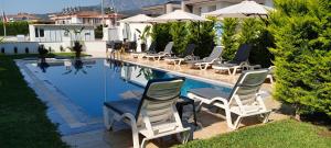 a group of chairs sitting next to a swimming pool at Tanem Suit in Kemer