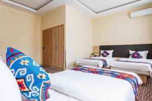 a room with two beds and a door at Solief Hotel in Tashkent